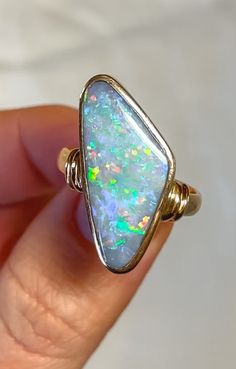 Discover timeless elegance with our 18ct Yellow Gold Solid Opal Ring, a true masterpiece in craftsmanship and design. Handcrafted from luxurious 18-carat yellow gold, this ring showcases a mesmerizing asymmetric opal centerpiece, exuding natural iridescence and a kaleidoscope of colors with every movement. The opal, renowned for its captivating play-of-color, is securely set within a sleek and modern design, creating a striking contrast against the warm glow of the gold band. The minimalist yet Luxury Opal Ring For Gift, Opal Rings With Polished Finish For Formal Occasions, Formal Opal Rings With Polished Finish, Formal Opal Ring With Polished Finish, Classic Yellow Gold Opal Ring, Luxury Ethiopian Opal Ring As A Gift, Formal Yellow Gold Ethiopian Opal Ring, Luxury Ethiopian Opal Ring For Gift, Luxury Ethiopian Opal Ring As Gift