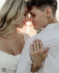 a man and woman embracing each other in front of the ocean