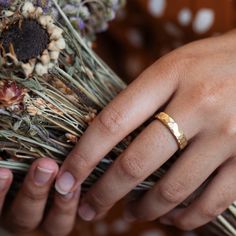 a close up of a person's hand with a wedding ring