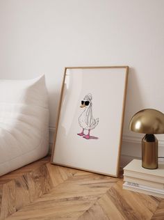 a white swan with sunglasses on its head is sitting next to a lamp and some books