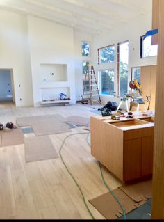 an empty room with hard wood flooring and construction tools on the ground in front of it