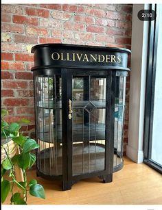 an old fashioned black cabinet sitting in front of a brick wall