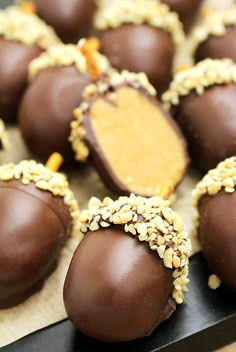 chocolate covered candies with nuts and peanut butter in the middle on a wooden table