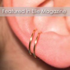 a close up of a person's ear with two gold rings on top of it