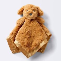 a brown teddy bear sitting on top of a blanket