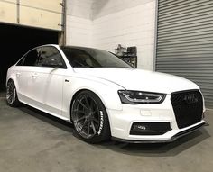 a white car parked in front of a garage door