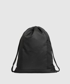 a black drawsack bag on a white background with the back pocket open and two zippers at the bottom