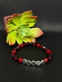 Black & Red Dance Stretchy Bracelet About the product  Colors: Black & red  Materials: Glass & Acrylic  * This one of a kind bracelet would be perfect to bring a smile to your friends and family. It is lightweight and fashionable, as well as stretchy. It's the perfect gift for family members or friends that love dance! * Contact and Follow Us!  If you have any questions about this bracelet feel free to message us on Etsy. We will be happy to answer them.  Shop our store:  https://www.etsy.com/shop/Toparadiseandbeyond Facebook: https://m.facebook.com/To-Paradise-And-Beyond-194702878032699/ Instagram: https://www.instagram.com/toparadiseandbeyondco/ Casual Black Beaded Bracelets For Valentine's Day, Trendy Red Bracelets For Party, Flexible Red Jewelry For Gift, Personalized Red Stretch Bracelet, Casual Style, Adjustable Personalized Red Wristband, Personalized Red Name Bracelet With Round Beads, Red Stretch Bracelet For Friendship In Trendy Style, Red Trendy Stretch Bracelet With Letter Beads, Trendy Red Stretch Bracelet With Letter Beads