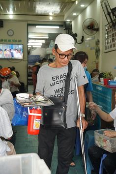 a man with a cast on his arm is standing in a room filled with people