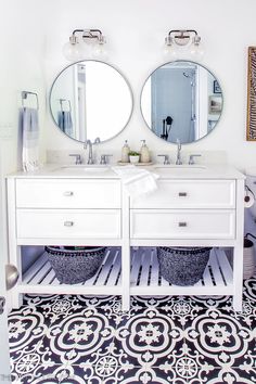 a bathroom with two sinks and mirrors on the wall above it is decorated in black and white