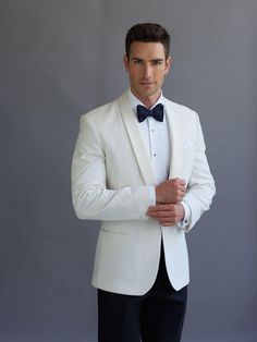 a man in a white suit and bow tie