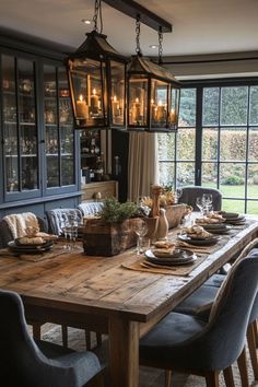 a dining room table is set with place settings and candles in front of the windows