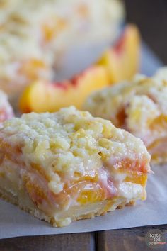 two pieces of cake sitting on top of a piece of paper next to some peaches