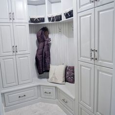 a white closet filled with lots of cupboards and pillows on top of each other