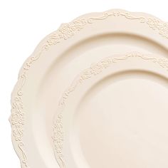 three white plates with ornate designs on them, one is empty and the other has a fork in it