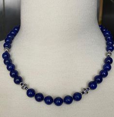 This gorgeous necklace of round lapis lazuli beads with sapphire and white gold accents is the epitome of style and sophistication! 10mm round, beautifully matched lapis with their high-polish and stunning royal blue color have been arranged with 18k white gold rondels, faceted blue sapphire beads and white gold rondels. The larger white gold rondels are set with tiny sparkling sapphires that complement the lapis perfectly, and the white gold accents have a lovely stardust finish, treating your eyes to a wonderful combination of sizes, shapes, color and textures. Hand strung on silk thread and finished with a 14k white gold clasp, this necklace is a great way to show off your sense of style and that undefinable look of understated, effortless elegance! Necklace measures 19 inches in length Sapphire Jewelry With 8mm Beads, Necklace With 8mm Round Lapis Lazuli Beads, Elegant Beaded Necklaces With Round Lapis Lazuli Beads, Elegant Lapis Lazuli Beaded Necklaces With Round Beads, Lapis Lazuli Round Beaded Necklaces, Elegant Lapis Lazuli Beaded Necklace With Round Beads, Lapis Lazuli Necklace With 8mm Beads, Lapis Lazuli Necklaces With 8mm Beads, Elegant Round Lapis Lazuli Beaded Necklaces