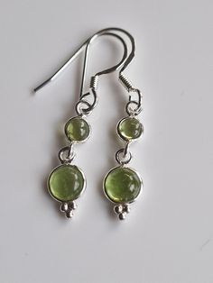 "Sterling silver drop peridot  dangle  earrings with AAA green crystals handmade with care.   High quality materials, long-lasting and very sparkly.  Perfect gift for women and girls, makes an ideal stocking filler, Valentine's Day gift, Mother's Day gift, Anniversary gift and birthday gift, these earrings come gift wrapped. Some believe peridot  is derived from the Arabic faridat, meaning \"gem,\" or from the Greek word, peridona, which means \"give in abundance.\" Given its resemblance to the Silver And Green Earrings, Green Earring, Peridot Jewelry Silver, Green Gem Earrings, Silver Vintage Earrings, Charms Earrings, Silver Peridot Jewelry As Gift, Silver Dangle Earrings, Earrings Silver