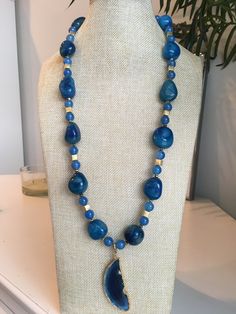 a necklace with blue beads on a mannequin