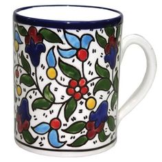 a white and blue coffee mug with floral designs on the outside, sitting in front of a white background