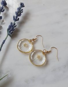 the dandelion earrings are made from glass and gold plated brass, with small flowers