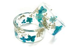 two glass bracelets with blue flowers and butterflies on them, sitting next to each other