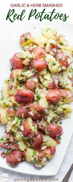 potatoes with garlic and herb smashed red potatoes on a white platter next to a fork