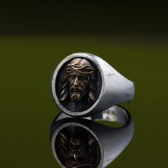 "Are you looking for a unique and meaningful piece of Christian jewelry? Check out this stunning Jesus Ring! Crafted with love and precision by a skilled jeweler, it features a Sterling silver signet ring adorned with a beautiful bronze Jesus Christ head.This exquisite ring not only makes a stylish statement but also serves as a symbol of faith and devotion. It's perfect as a Christmas gift, a reminder of the true meaning of the holiday. The combination of Sterling silver and bronze creates a ca Spiritual Hallmarked Signet Ring Gift, Symbolic Hand Forged Engraved Ring For Gift, Symbolic Hand-forged Engraved Ring As A Gift, Symbolic Hand Forged Engraved Ring As Gift, Unique Brass Signet Ring For Gift, Unique Brass Signet Ring Gift, Bronze Engraved Rings For Gift, Bronze Engraved Rings Ideal For Gifts, Engraved Bronze Rings Ideal For Gifts