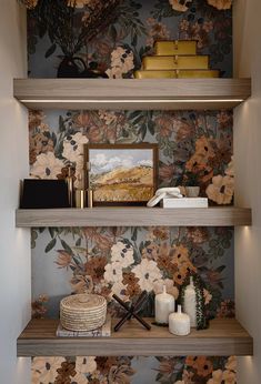 the shelves are decorated with floral wallpaper and decorative bookshelves, along with vases