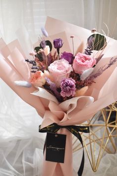 a bouquet of flowers is wrapped in pink paper