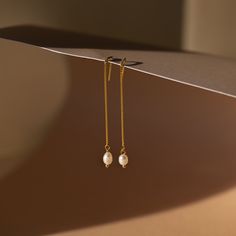 It’s as easy as pie to throw on our Pearl Threader Earrings and put an outfit together. Glamorous and dainty, these dangling charm earrings are minimalistic and perfectly stack with other earrings in your collection. Material: High Quality Solid 925 Sterling Silver Finish: 18K Gold ∙ Sterling Silver Featuring ~0.7mm Thick Chain Earrings ~60mm in Length, with a ~5.5x4.5mm Pearl Charm Sold as a pair Part of our Pearl Collection Model showcases a glamorous, event-ready look featuring Pearl Station Minimalist Single Pearl Earring For Everyday Elegance, Minimalist Dangle Linear Earrings As Gift, Minimalist Drop Pearl Earrings, Minimalist Pearl Drop Earrings For Everyday, Minimalist Pearl Drop Earrings For Everyday Elegance, Minimalist Everyday Pearl Drop Earrings, Minimalist White Threader Earrings For Everyday, Minimalist 14k Gold Earrings For Everyday Elegance, Elegant Dangle Threader Earrings For Everyday