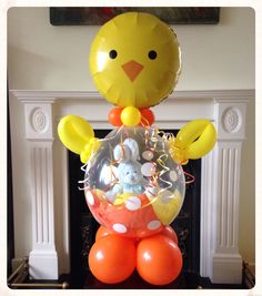 a balloon in the shape of a chick with balloons around it and a teddy bear inside