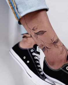 a woman's foot with a flower tattoo on her left ankle and the bottom part of her leg