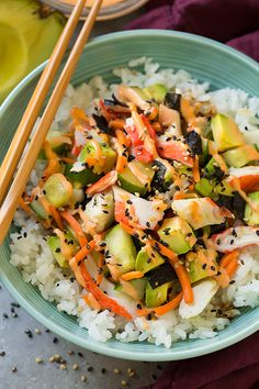 a bowl filled with rice and vegetables next to chopsticks on top of it