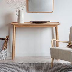 a wooden table with a mirror on it next to a chair