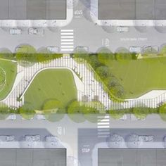 an aerial view of a parking lot with trees and grass in the middle of it