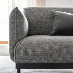 a gray couch with two black pillows on it