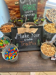 a wooden table topped with lots of different types of snacks and treats on top of it