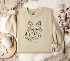 "Minimalist Line Art Fox Crewneck Sweatshirt - Unisex Comfort Fit Embrace the elegance of nature and minimalist design with our \"Minimalist Line Art Fox Crewneck Sweatshirt.\" Perfect for the modern wardrobe, this sweatshirt combines comfort, style, and ethical manufacturing to give you a garment you'll love to wear and show off. Key Features: Unisex Design: Ideal for any situation, this heavy blend crewneck sweatshirt offers pure comfort for everyone. Its unisex design ensures it fits perfectly, regardless of your style. Quality Material: Made with a medium-heavy fabric blend of 50% cotton and 50% polyester (8.0 oz/yd² (271.25 g/m this sweatshirt promises coziness during colder months. Heather Sport colors come in a 60% polyester, 40% cotton blend. Durable and Comfortable: The classic fi Art Fox, Fox Sweater, Fox Shirt, Fox Lover, Minimalist Line Art, Men Gifts, Sweater Cute, Sweater For Women, Cute Fox