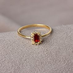 It is a stone that represents passion, true friendship, loyalty, success and consistency. It has names such as dreaming, garnet and mercy stone.. Our rectangular garnet stone ring surrounded by real diamonds will add elegance to your hands. It is a ring that you can use both on special occasions and in daily life. It is a beautiful and stylish product that you can gift to yourself and your loved ones. The color of those born in January is Garnet. Our necklace compatible with our ring; https://qu Luxury Gold Diamond Ring With Birthstone, Gold Emerald-cut Cluster Ring With Halo Design, Gold Emerald Cut Cluster Ring With Halo Design, Gold Emerald-cut Halo Cluster Ring, Gold Emerald Cut Halo Cluster Ring, Elegant Christmas Celebration Jewelry, Gold Cubic Zirconia Cluster Ring With Halo Design, Formal Cubic Zirconia Birthstone Ring, Elegant Brilliant Cut Ruby Ring Gift