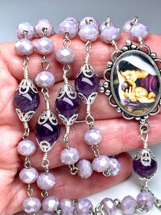 Purple Amethyst & Lavender Czech Beaded Rosary (21 Inches Long) Your beautiful rosary will come nicely packaged in an organza pouch with a "How To Pray The Rosary" pamphlet included.  This rosary has not been blessed, so please have your priest bless your rosary after receiving it if you want. Materials Used: 2 Inch Italian Silver Oxidized Trinity Crucifix, Silver Plated Mother Mary & Jesus Image Bezel Center, Six 10mm Smooth Amethyst Pater Beads, Beautiful 8mm Faceted Lavender Czech Rondelles, One Chain Piece for the Dangle, One Silver Plated Heart for Dangle, 36 Silver Plated Bead Caps, Wire for Wrapping, Silver Pins as well AMETHYST: believed to enhance intuition & repel negativity of all kinds. Known as  a healing, protection, power and wisdom stone. Symbolizes humility, sincerity, and Adjustable Beaded Purple Rosary Bracelet, Purple Beaded Rosary Bracelet, Purple Beaded Rosary As Gift, Handmade Adjustable Purple Rosary, Amethyst Rosary, Pray The Rosary, Beautiful Rosary, Beaded Rosary, Bohemian Hand-strung Rosary With Round Beads