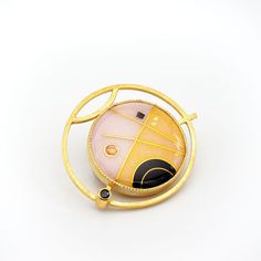 This modern convertible brooch pendant has a 24K gold cloisonne vitreous enamel on silver jewel in a geometric design with deep black, petal pink and warm yellow set into gold vermeil over sterling silver with faceted black spinel, enamel measures 1" diameter, overall 1.5" Luxury Gold Enamel Brooch, Luxury Gold Enamel Brooches, Gold Brooch With Large Pendant As Gift, Modern Enamel Jewelry With Gemstone, Luxury Gold Enamel Pin As Gift, Luxury Gold Enamel Pin For Gift, Luxury Gold Enamel Pin Gift, Yellow Gold Enamel Brooch Jewelry, Gold Modernist Brooch For Formal Occasions