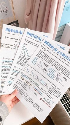 two hand holding papers with graphs on them