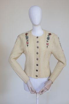 "Classic Austrian style hand knitted wool ivory cardigan. The cardigan features a delicate symmetrical floral embroidery. Fastens with metal vintage buttons. Great vintage condition. Condition: Perfect vintage condition.  Measurements: Best Fits: XS-S All measurements are taken lying flat and have already been doubled. Shoulders: 44cm / 17\" Sleeves: 48 / 19'' Chest: 110 cm / 43\" Length: 53 m / 21\"" Vintage Cream Sweater With Floral Embroidery, White Vintage Cardigan With Floral Embroidery, Fitted Cream Sweater With Buttons, Vintage Cream Embroidered Cardigan, Vintage Embroidered Cream Cardigan, Winter Embroidered Cream Cardigan, Cream Embroidered Winter Cardigan, Winter Cream Embroidered Cardigan, Vintage Knitted Spring Cardigan