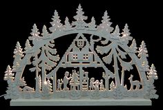 an illuminated christmas scene in the shape of a house surrounded by trees and snowflakes