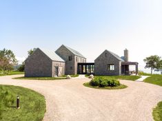 a stone house sits on the side of a gravel road