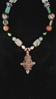 Welcome to my store. Please check all dimensions given. Here we have a rare Vintage / Antique Ethiopian Coptic Cross as the center piece of this beautiful necklace. This piece, in addition to the Cross has some wonderful components. There are small bone repoussé beads, Moss Agate, Aventurine, Antique Chinese silver white Onyx, electroplated stone, glass and spacer beads. This is a subtle fashion statement necklace and One of a Kind. Spiritual Beaded Cross Pendant Necklace, Spiritual Beaded Cross Pendant Jewelry, Bronze Cross Bohemian Necklace, Bronze Bohemian Cross Necklace, Bohemian Bronze Cross Necklace, Handmade Silver Copper Necklace, Bohemian Cross Pendant Jewelry Gift, Handmade Spiritual Cross Pendant Jewelry, Handmade Silver Cross Pendant Necklace