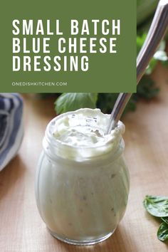 small batch blue cheese dressing in a glass jar with a spoon and basil leaves around it