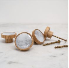 three wooden ear plugs sitting on top of a white marble counter next to screws