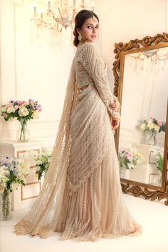 Taking inspiration from Ornamental art, this stunning Lehenga saree features monotonal threadwork further enhanced with pearls, sequins, crystals, beads and Swarovski stones. This look is completed with embroidered pleated flowy lehenga & embellished embroidered net stylized dupatta which can be hooked and worn as per your comfort creating gorgeous saree silhouette making it an ideal choice for any celebratory occasion. Fabric: Embroidered NetColor: Beige This is a made to measure look, once ord Flowy Lehenga, Saree Silhouette, Gorgeous Saree, Ornamental Art, Designer Outfit, Crystals Beads, Swarovski Stones, Lehenga Saree, Pakistani Designers