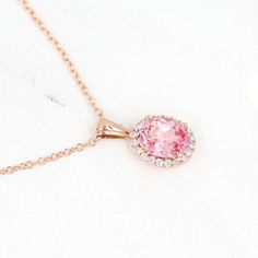 The Charlotte necklace has all the dainty elegance of royalty, with a generous 1.8ct peachy-pink created sapphire center, mine-free diamond halo, and delicate chain of 14k rose, yellow, white gold, or platinum. This design is not only a beautiful necklace, but also is available as a ring. Details: 16-18" adjustable chain with lobster clasp 14k rose, yellow, or white gold, or platinum 9x7mm (1.8ct equivalent) peachy-pink created sapphire center stone 0.21ct total weight — lab-grown diamonds *All diamonds are DEF color, VS1 clarity or better *Please note that colored gemstones may vary slightly in color. We do our best to accurately portray the color of our gemstones, but exact color and saturation may vary based on gem characteristics, lighting and photography conditions, and the screen dis Rose Gold Pink Sapphire Jewelry With Halo Setting, Fine Jewelry Rose Gold Necklace With Halo Design, Pink Sapphire Jewelry With Halo Design, Rose Gold Pink Sapphire Round Cut Jewelry, Formal Rose Gold Halo Necklace, Rose Gold Jewelry With Pink Sapphire And Diamond Accents, Rose Gold Jewelry With Diamond Accents And Pink Sapphire, Elegant Pink Sapphire Round Necklace, Delicate Rose Gold Jewelry With Halo Setting